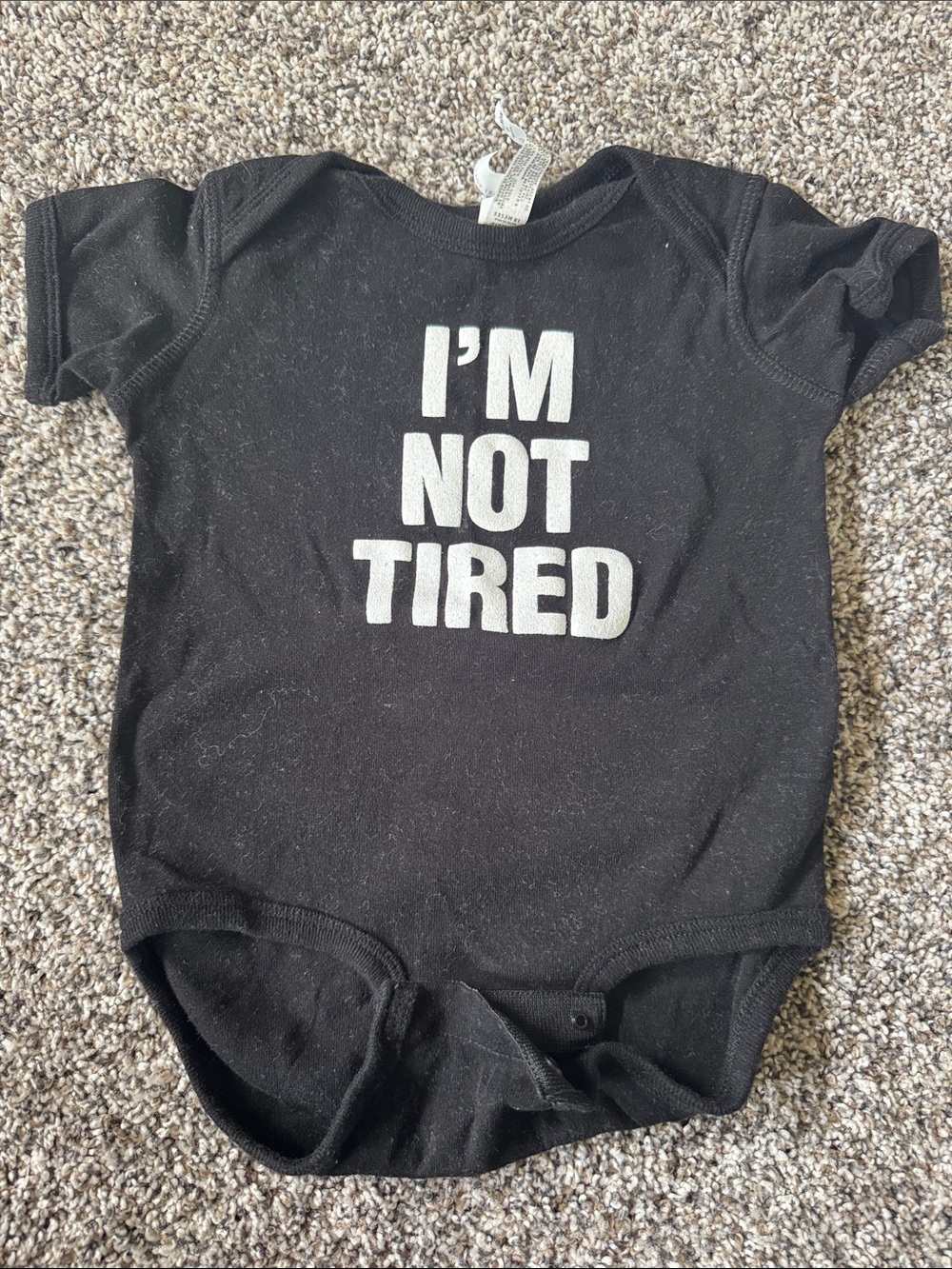Rabbit Skins Black Baby Bodysuit with White "I'M NOT TIRED" Text